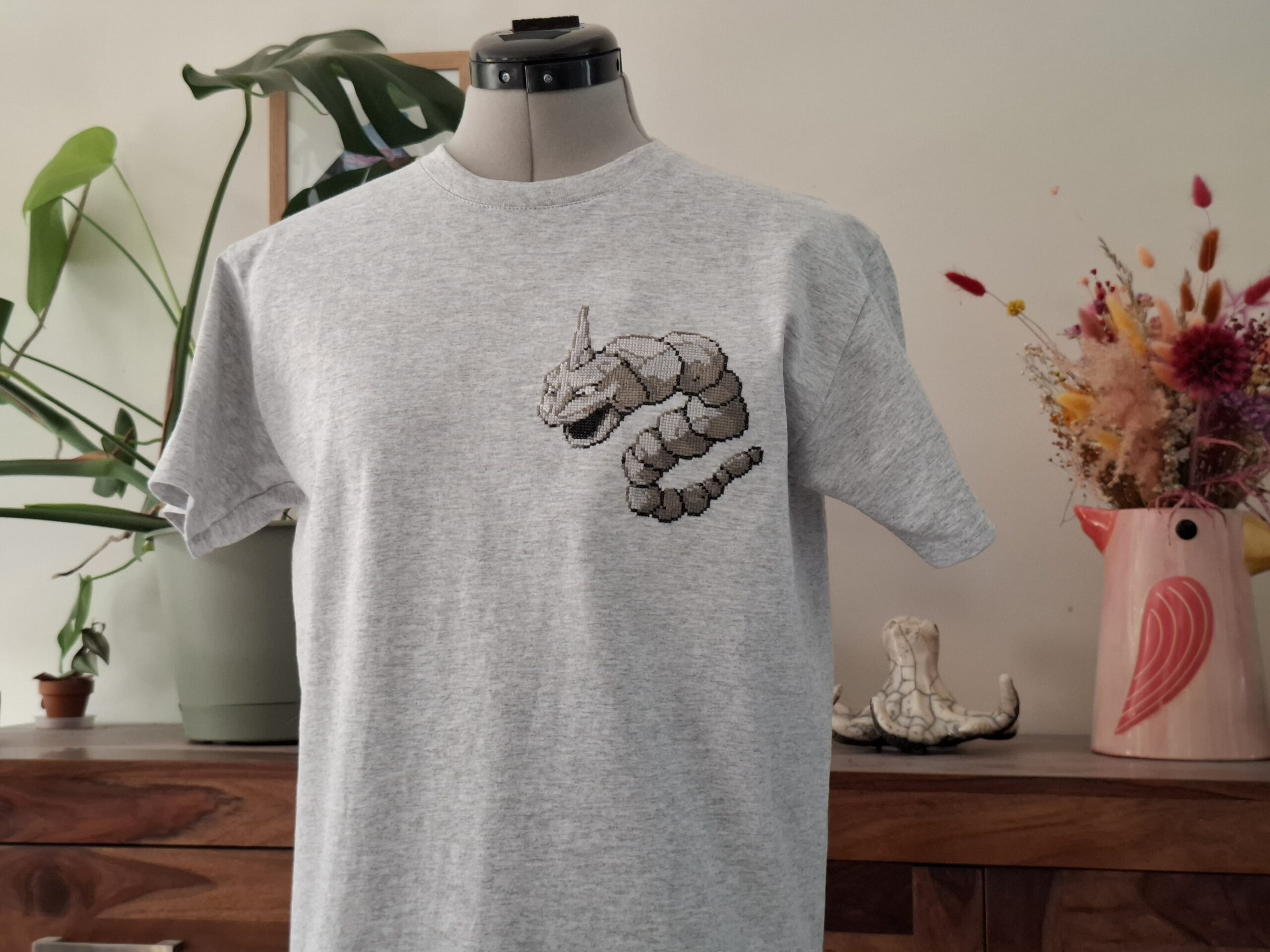 T-shirt onix porté par un mannequin de couture, des plantes et une sculpture de poulpe en arrière plan.